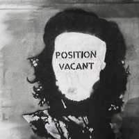 A black-and-white stencil portrait on a wall with the words 'POSITION VACANT' across the face.